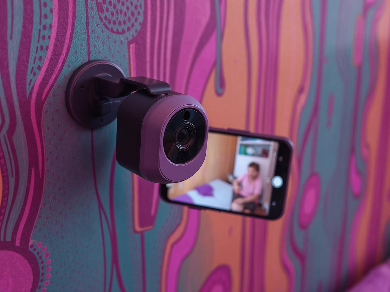 A compact Wyze Cam v3 mounted on a colorful nursery wall, streaming high-definition video to a parent's smartphone.